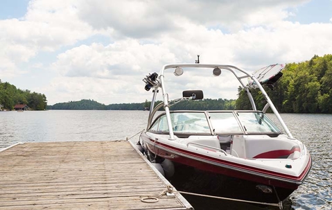 Red boat to be fumigated for termites docked on a pier on a lake.